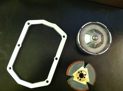 1981 Garelli Rally Sport - Disassembled clutch components, including a gasket, clutch disc, and drum, are laid out on a dark surface.