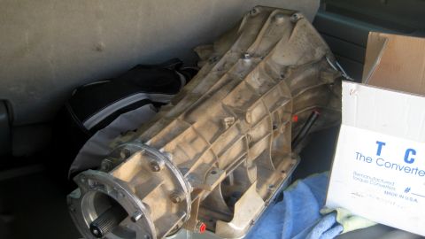1996 Ford Bronco - A transmission and a box for remanufactured torque converters are seen inside a vehicle.