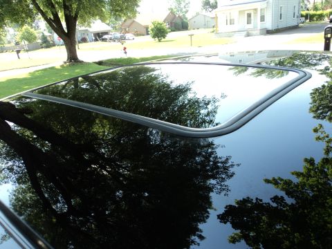 2004 Mercury Grand Marquis - Close-up of a car's sunroof, reflecting the surrounding environment and showing a website logo.