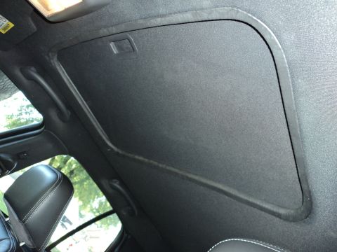 2004 Mercury Grand Marquis - The interior of a vehicle shows a closed sunroof and part of the headliner, with a visible warning label.