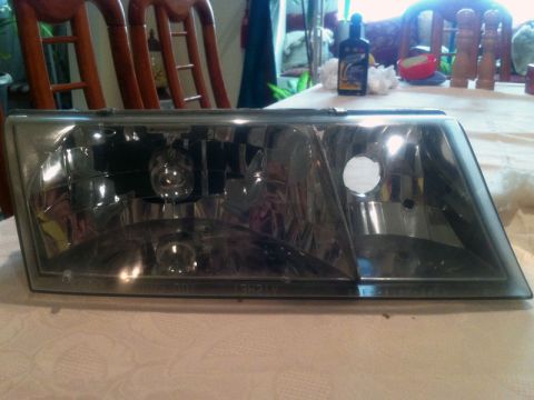 2001 Mercury Grand Marquis - Headlight assembly shown on a table, with text '13V 24W' visible on the lower edge.