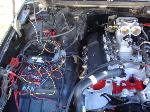 1989 Ford Bronco - A close-up view of a vehicle's engine bay, showing complex wiring and engine components.