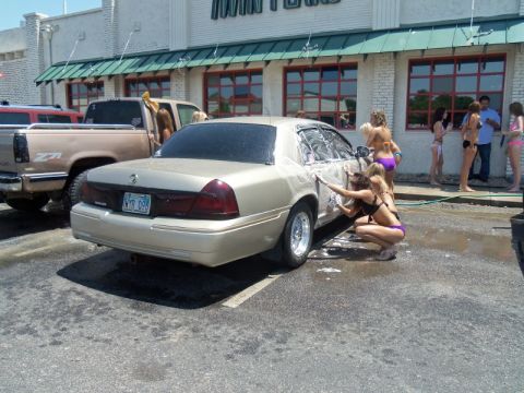 2000 Mercury Grand Marquis - A gold 2000 Mercury Grand Marquis is being washed by women in bikinis at a car wash.