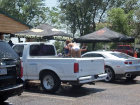 2000 Mercury Grand Marquis - Two vehicles are parked under tents, one is a white pickup truck and the other is a white coupe.