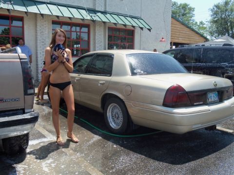2000 Mercury Grand Marquis - A tan sedan and a pickup truck are at a car wash with a woman holding a towel.