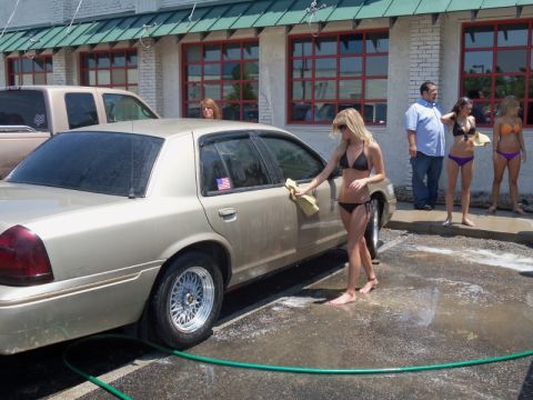 2000 Mercury Grand Marquis - A group of people are at a car wash with a 2000 Mercury Grand Marquis and another vehicle.