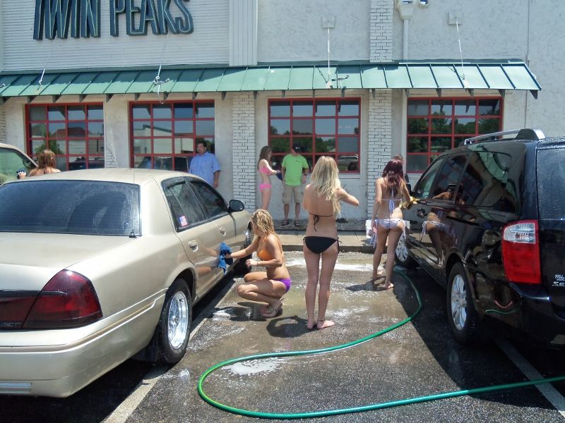 Gold sedan and black minivan at a car wash, women washing cars