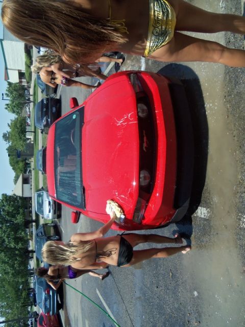 2000 Mercury Grand Marquis - Women in bikinis washing a red Ford Mustang at a car wash.