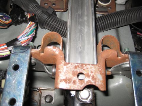 2005 Jeep Wrangler - Close-up of a rusted metal bracket with wiring and conduit, likely part of a vehicle's interior.
