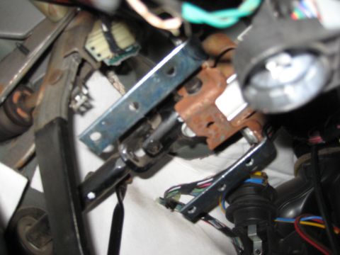 2005 Jeep Wrangler - This image shows a close-up view of the steering column and ignition switch area under the dashboard of a vehicle. Various wires, metal bra…