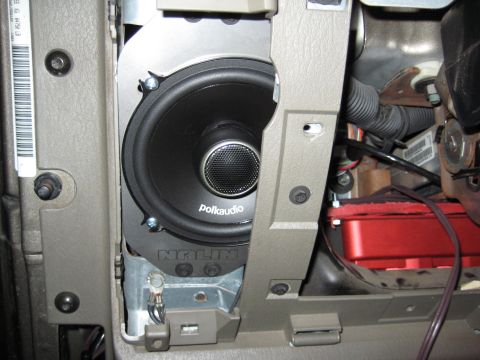 2005 Jeep Wrangler - Close-up of a Polk Audio coaxial speaker with a mesh-domed tweeter newly mounted in a tan interior panel/kick-panel pod, with the trim open…