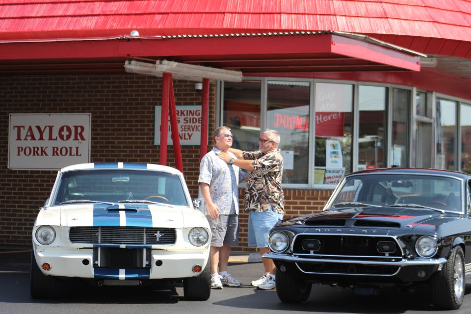 Black 1968 Shelby GT500 and white 1968 Shelby GT500 with blue stripes parked outside Dumars restaurant