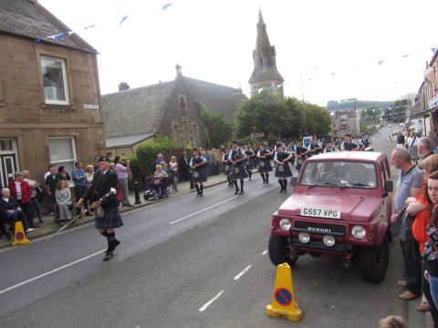 1968 Ford Mustang - A Suzuki Samurai participates in a parade alongside a bagpipe band in Scotland.
