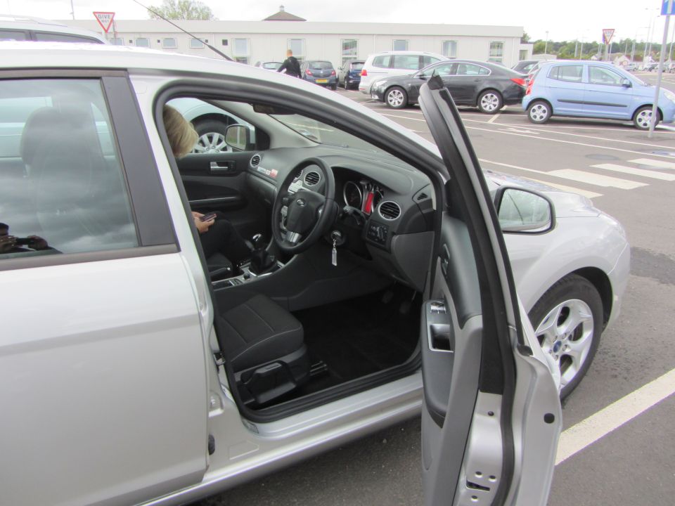 Silver car interior with open driver's door, dashboard and steering wheel visible