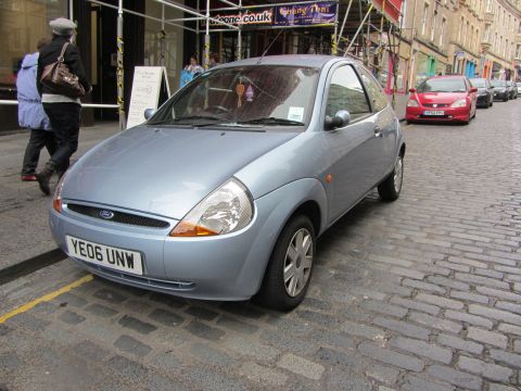 1968 Ford Mustang - A light blue Ford Ka is parked on a cobblestone street in Scotland, with other vehicles visible in the background.