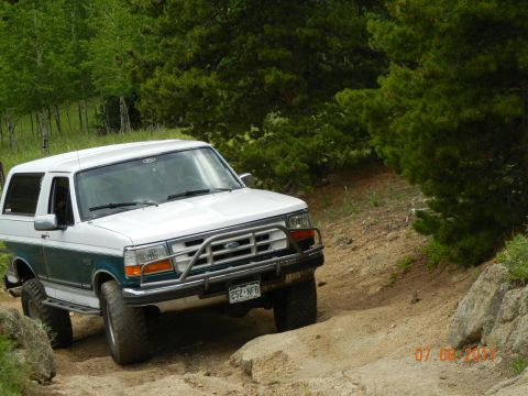 1996 Ford Bronco - This 1996 Ford Bronco navigates a challenging off-road path with large rocks and steep inclines.