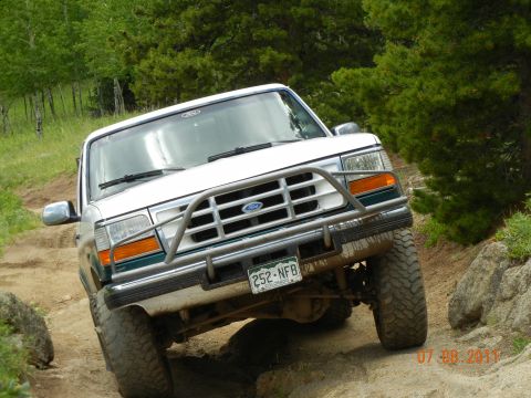 1996 Ford Bronco - This 1996 Ford Bronco navigates a rocky, off-road path surrounded by trees.