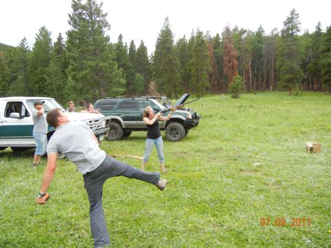1996 Ford Bronco - Two SUVs are parked in a field while people aim firearms.