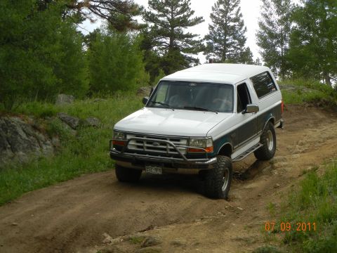 1996 Ford Bronco - This 1996 Ford Bronco navigates a dirt trail surrounded by trees.
