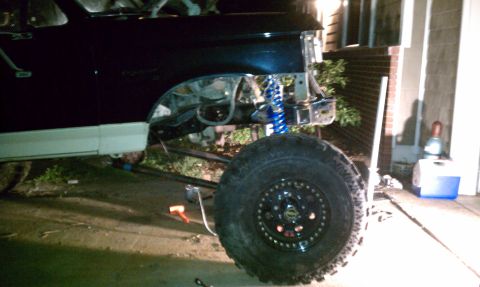1990 Ford Bronco - A lifted 1990 Ford Bronco is shown with its front end disassembled, revealing custom suspension components.