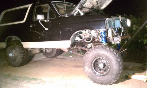 1990 Ford Bronco - This 1990 Ford Bronco features a lifted suspension and custom wheels, with its hood open for inspection.