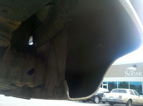 1996 Ford Bronco - The underside of a vehicle's bumper and frame are visible, with other vehicles in the background.