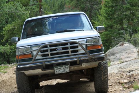 1996 Ford Bronco - This 1996 Ford Bronco navigates a , off-road path surrounded by trees.