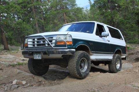 1996 Ford Bronco - This 1996 Ford Bronco is shown off-road with large tires and a protective brush guard.