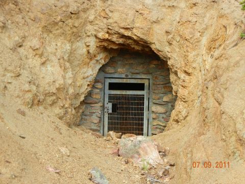 1996 Ford Bronco - Mine entrance with a metal barred door set into a rocky hillside.