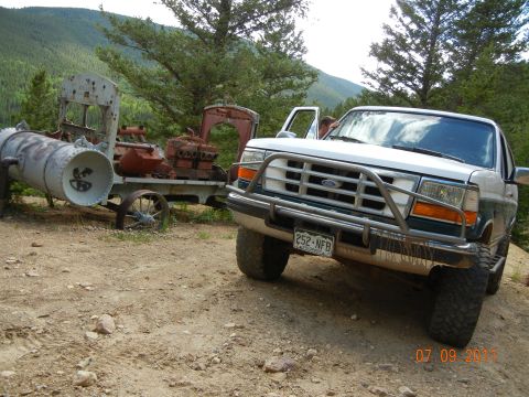 1996 Ford Bronco - 1996 Ford Bronco parked near old mining equipment in a mountainous area.
