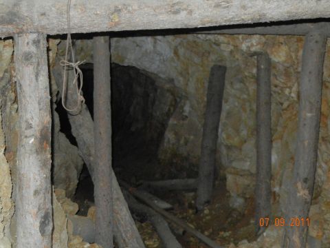 1996 Ford Bronco - Interior view of a mine shaft, showing wooden supports and old tracks on the ground.