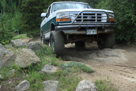 1996 Ford Bronco - This 1996 Ford Bronco is shown tackling a challenging off-road course with large rocks.