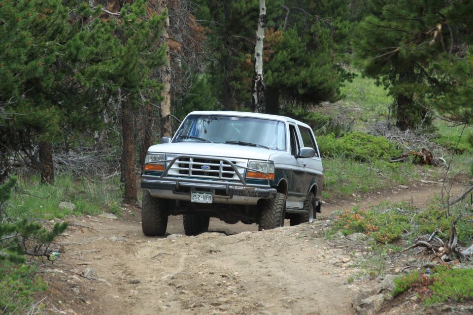 1996 Ford Bronco driving on a dirt road