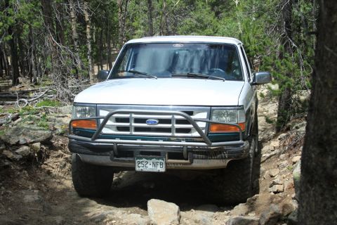 1996 Ford Bronco - This 1996 Ford Bronco navigates a challenging, rocky path through a wooded area.