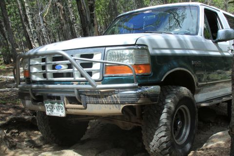 1996 Ford Bronco - 1996 Ford Bronco navigating a wooded off-road path.