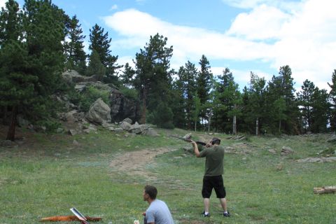 1996 Ford Bronco - Two men are target practicing with rifles in a natural outdoor setting with trees and rocks.