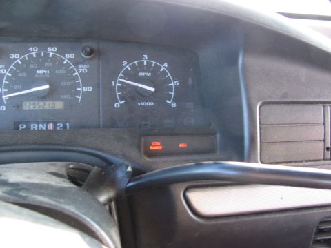 1995 Ford Bronco - The dashboard of a 1995 Ford Bronco shows the speedometer, tachometer, and 4x4 low range indicator illuminated.
