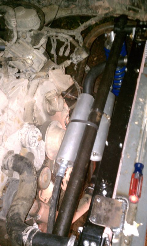 1990 Ford Bronco - Close-up view of an engine bay, showing various hoses and components. A screwdriver is visible.