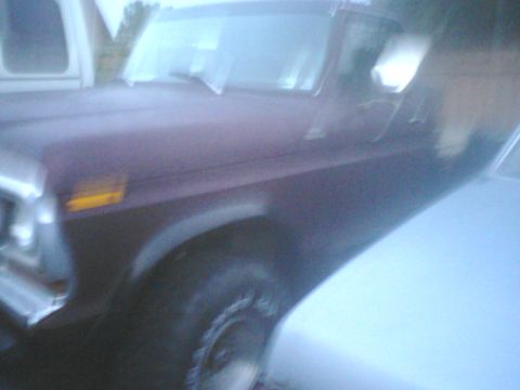 1988 Ford Bronco - A dark red SUV is parked next to a white vehicle, with a Supermotors watermark visible at the bottom right.
