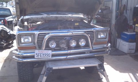 1978 Ford Bronco - The front of a 1978 Ford Bronco is shown with its hood up, revealing the engine bay.