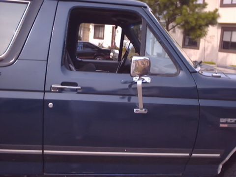 1990 Ford Bronco - Side view of a 1990 Ford Bronco, showing the door, mirror, and a glimpse inside.