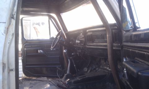 1978 Ford Bronco - The interior of a modified vehicle, likely from the 1970s, features a prominent roll cage and a worn dashboard.