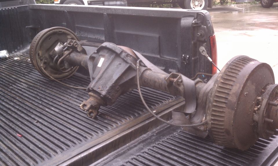 Rear axle assembly with differential and brake drums in a pickup bed