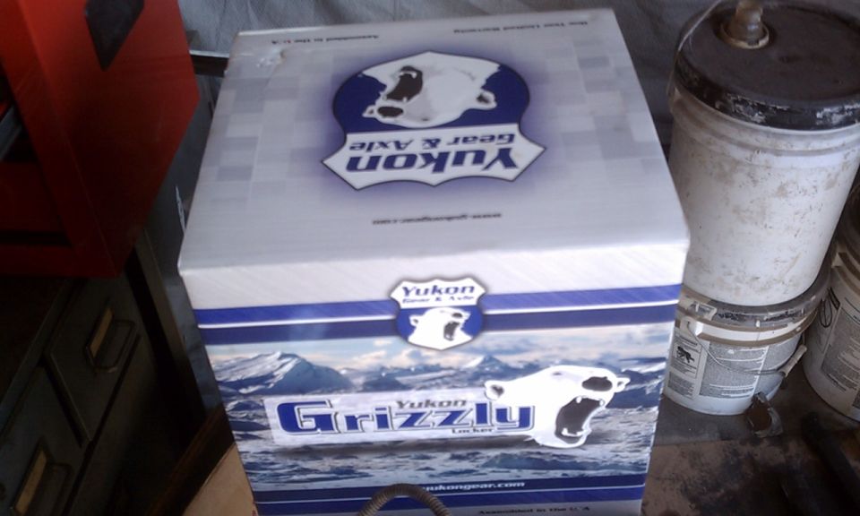 Yukon Grizzly Locker box with polar bear logo and mountain graphic, next to buckets