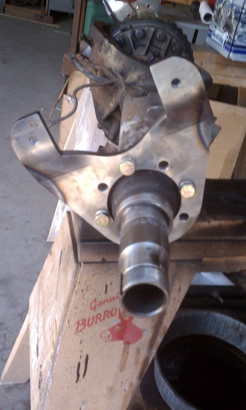 1978 Ford Bronco - Front axle assembly part shown with visible bolts and bracket. Text on a box indicates 'Genuine BURRO'.