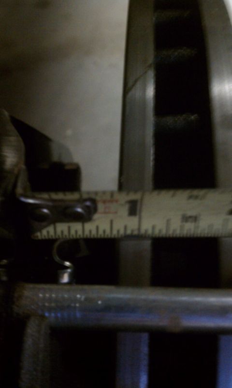 1978 Ford Bronco - A measuring tape is used to inspect a metal component, possibly for a vehicle part.