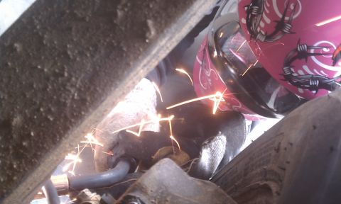 1978 Ford Bronco - Welding sparks fly as work is done on the underside of a vehicle.