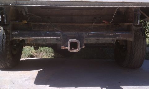 1978 Ford Bronco - The rear of a vehicle shows a trailer hitch receiver mounted to the bumper.