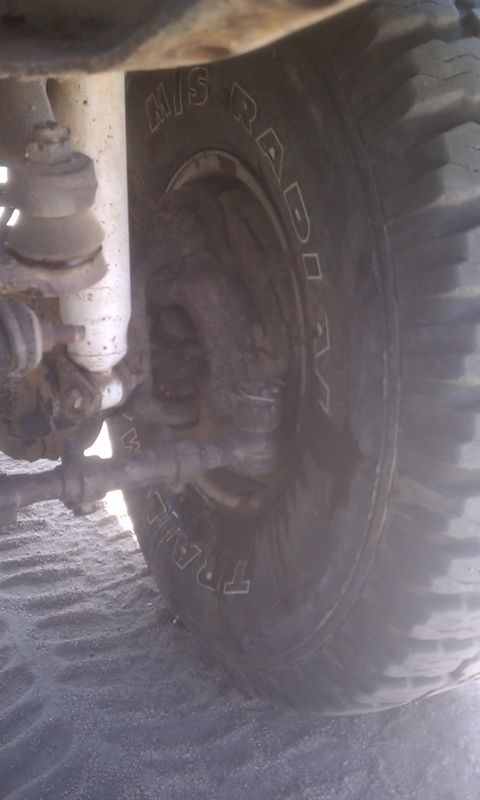 1978 Ford Bronco - Off-road tire and suspension components are visible in this close-up shot on sandy terrain.