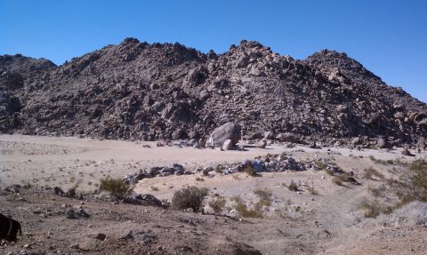 1978 Ford Bronco - Rocky desert terrain with mountains in the background and a clear blue sky overhead.